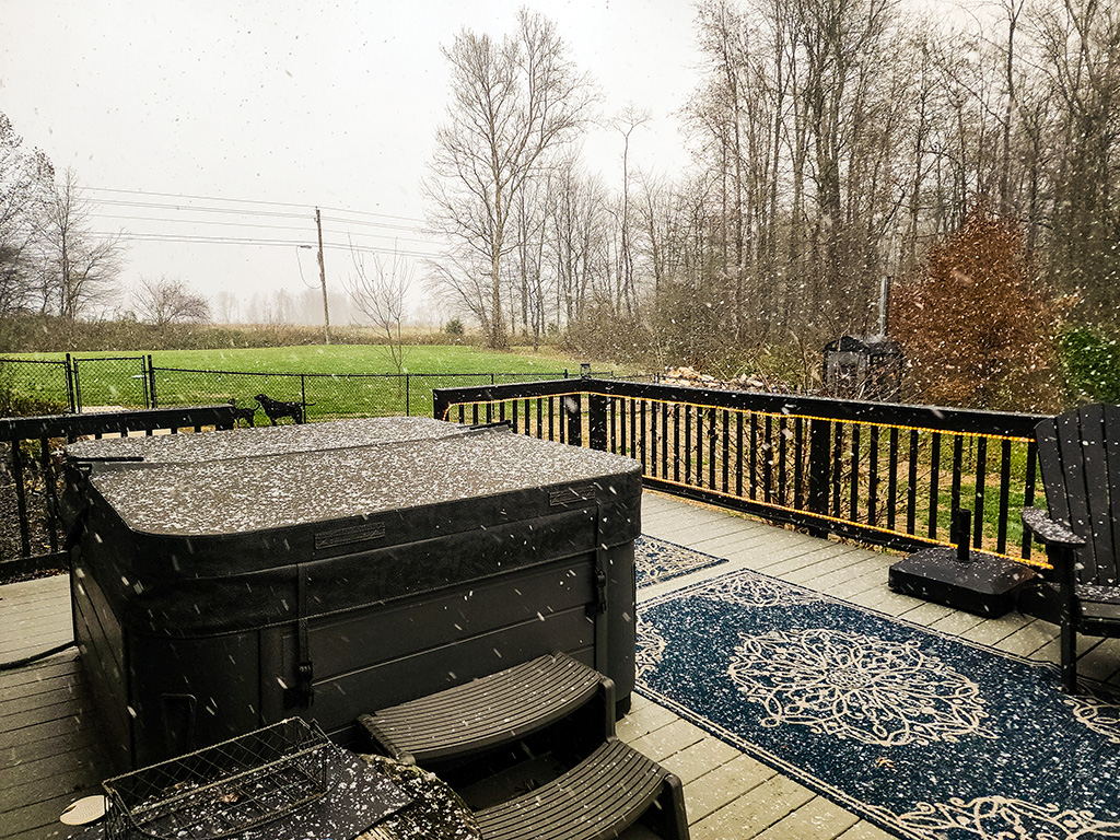 hot tub on deck with snow falling